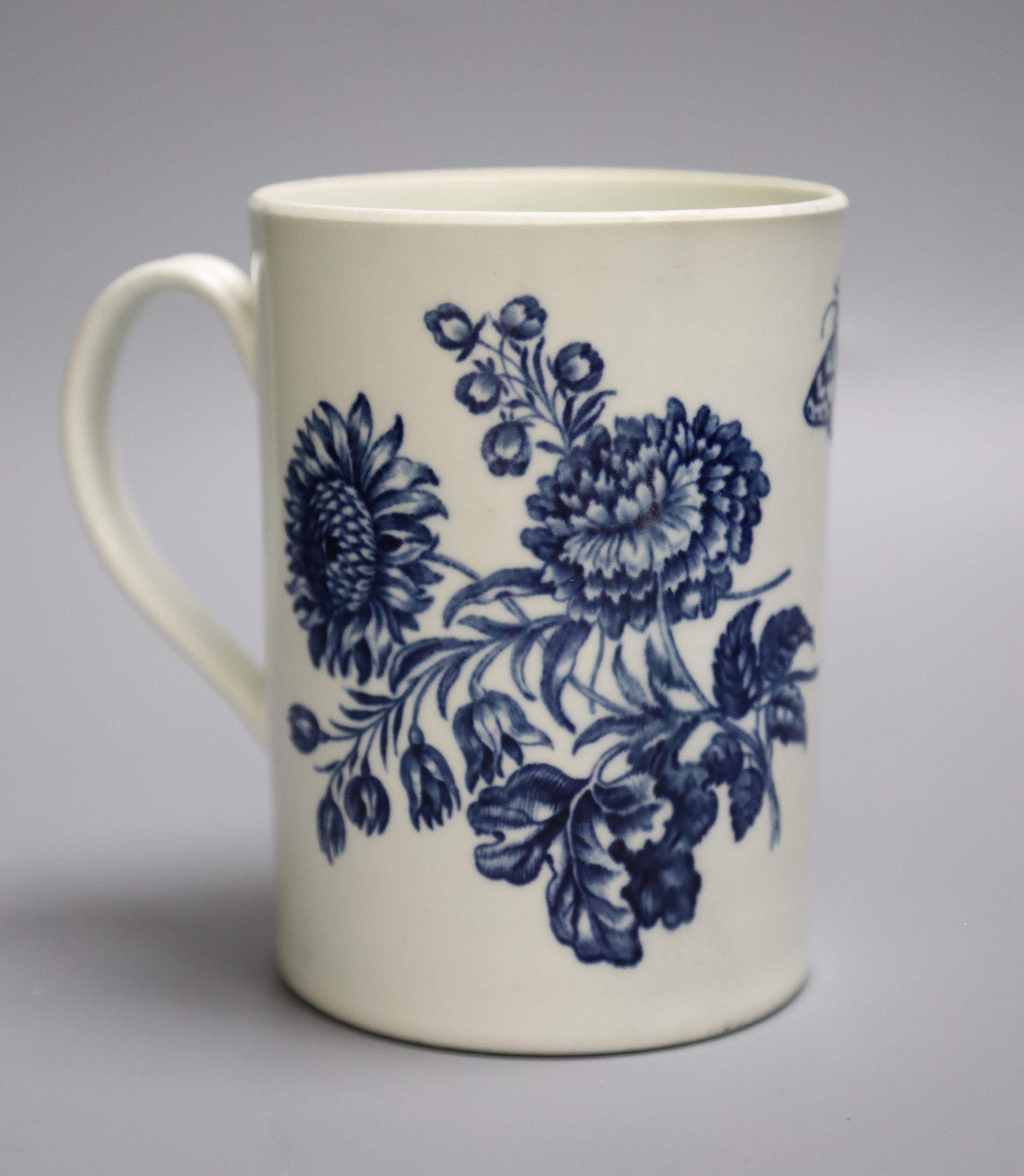 An 18th century Worcester mug decorated with large floral sprays, height 14cm